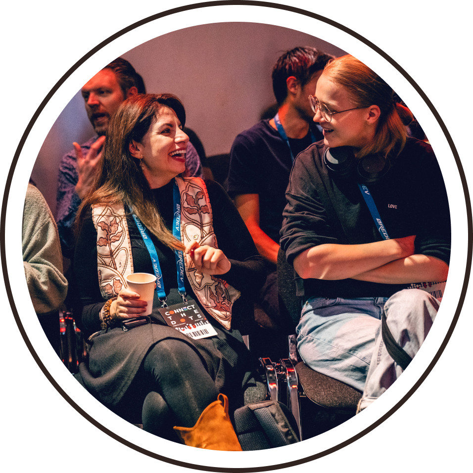 2 female delegates laughing in the audience at Øredev