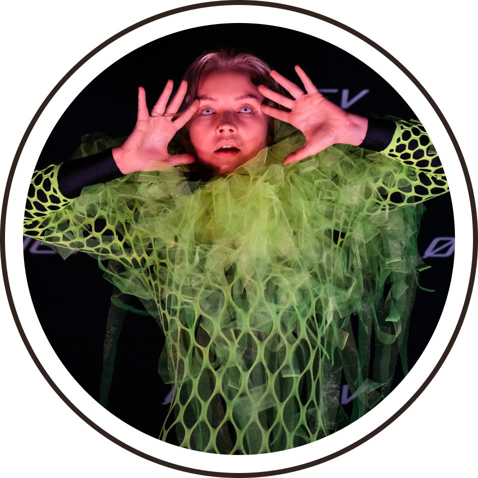 A dancer in a costume of green netting