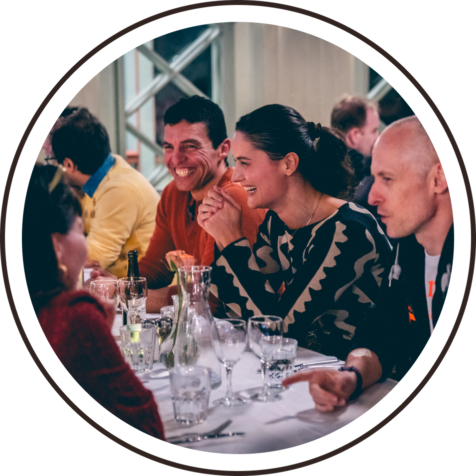 Members of the program committee laughing at a dinner table.