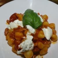 goodies of potatoes with bacon sauce and burrata flakes