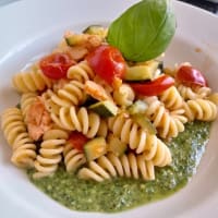 Fusilli with zucchini, salmon and tomatoes on arugula pesto