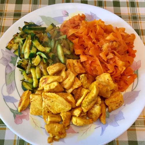 Piezas de pollo de oro con las zanahorias y el calabacín