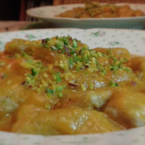 Whole wheat flour dumplings with pumpkin cream and chopped pistachios