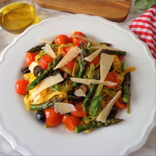 Green and yellow noodles with asparagus, cherry tomatoes and black olives