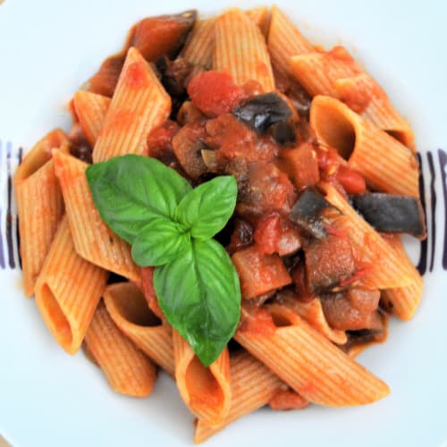 Pasta corta con sugo di pomodoro, melanzane, olive e basilico fresco