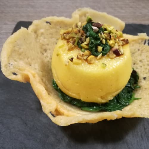 Cestino di parmigiano con letto di spinaci e tortino di polenta