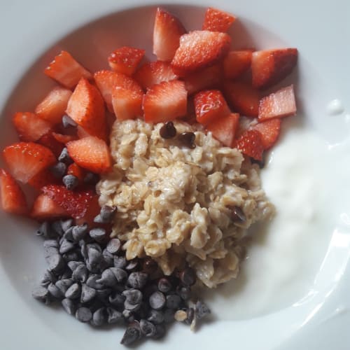 Porridge with strawberries, chocolate drops and yogurt