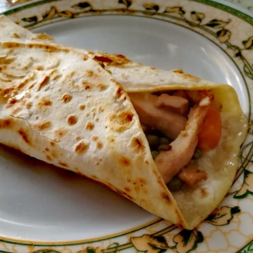 Piadina Wrap of chicken cut with mozzarella, peas and carrots.