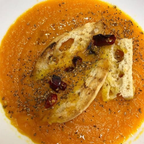 Sopa de calabaza con semillas de amapola, ajonjolí y aceite de chile.