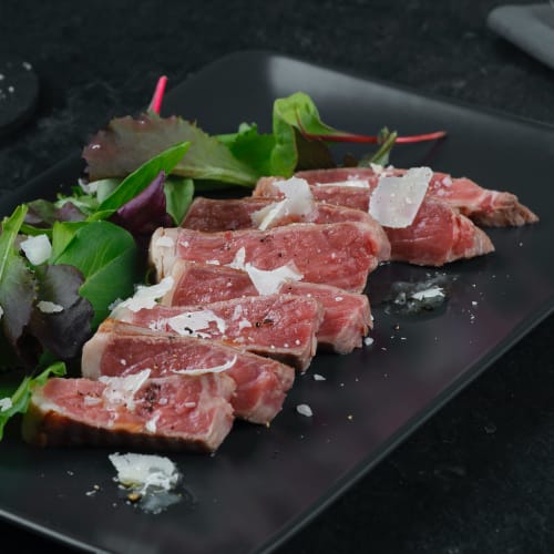 mediumrare beef tagliata with grana cheese and mixed wildleaf salad