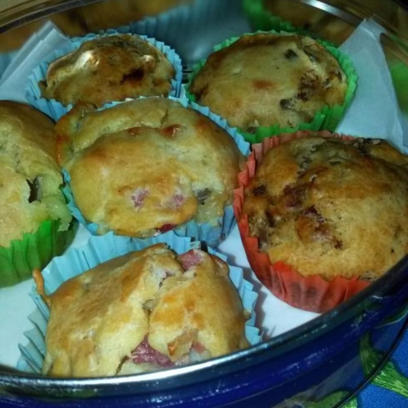 Salty muffins filled with spicy olives and dried tomatoes in oil