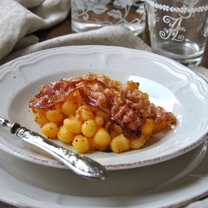 Ñoquis con crema de calabaza, las pasas y el tocino