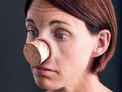 Manipulated image illustrating how  nasal congestion feels. Woman with a large cork where her nose would have been.