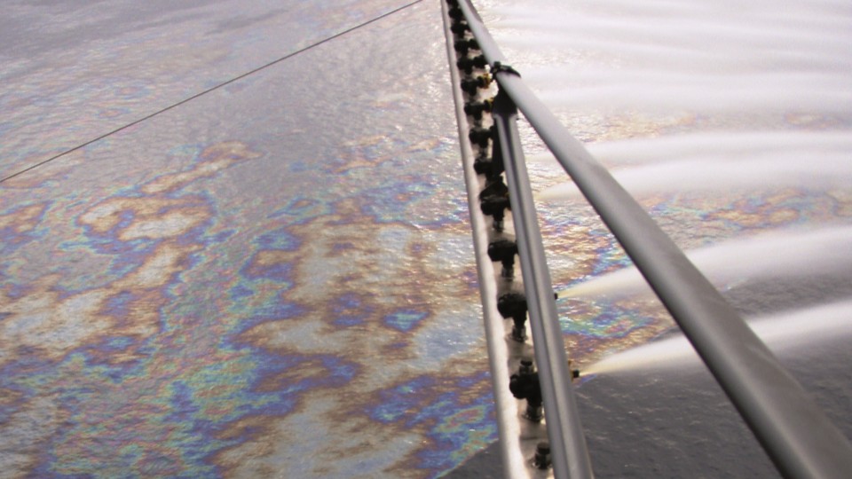 Surface dispersant application breaking oil into smaller droplets on the sea surface