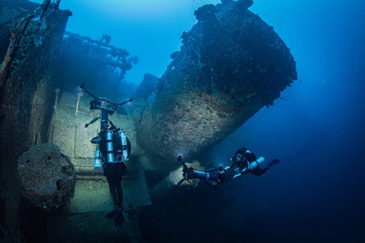 Divers conducting technical assessment on a historic shipwreck during pollution risk evaluation