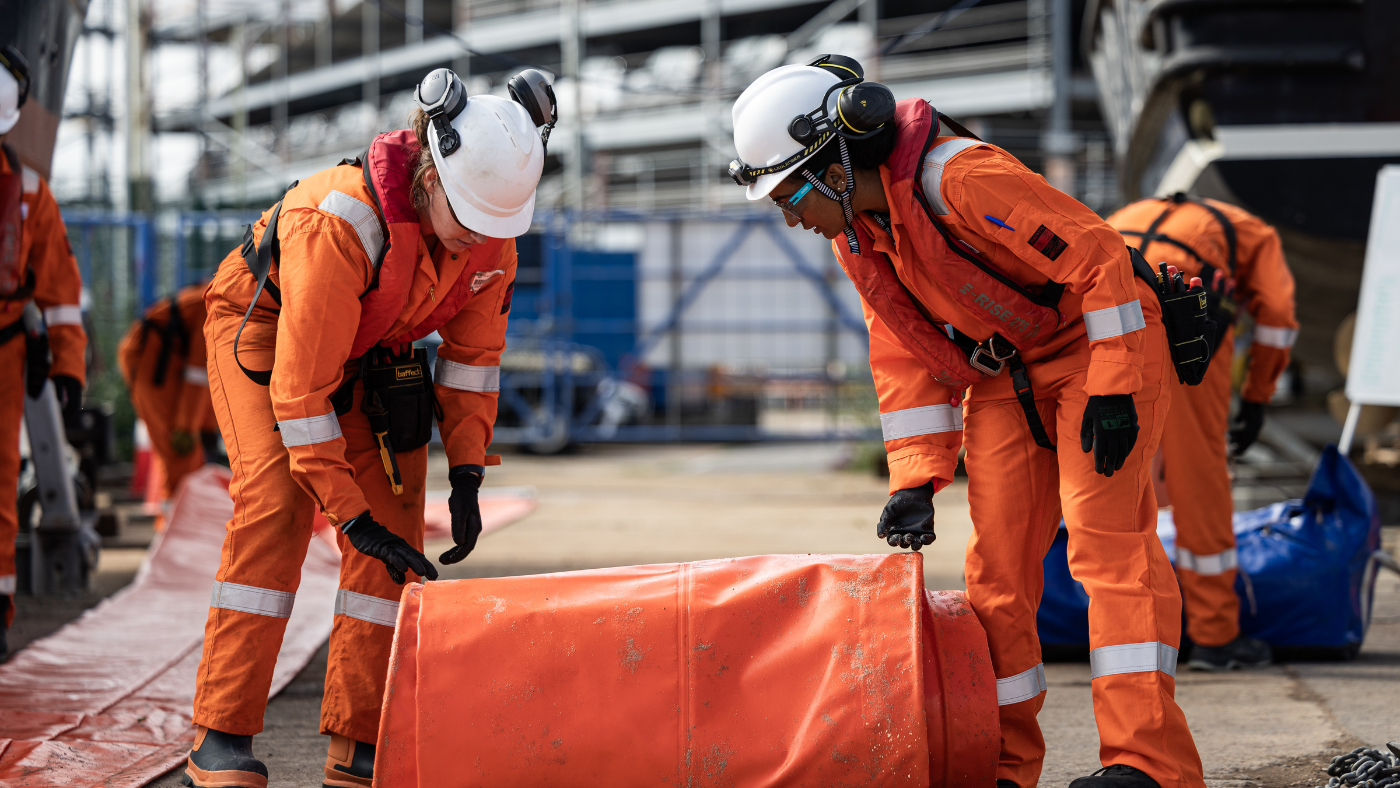 Responders reviewing and handling oil spill response equipment during a practical training exercise