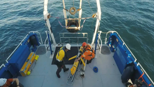 Response team handling an autonomous underwater vehicle (AUV) for subsurface oil spill tracking and environmental data collection.