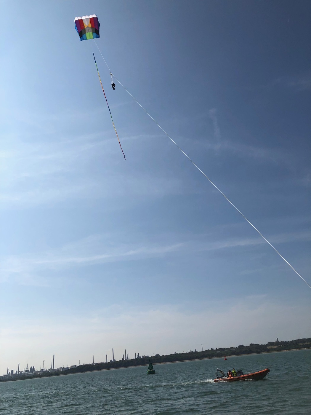 A colourful kite deployed with a mounted camera system for cost-effective aerial photography and oil spill surveillance at sea.