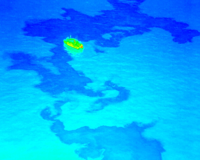 A thermal drone image showcasing oil spill patterns on water, enhancing detection accuracy during spill response missions.