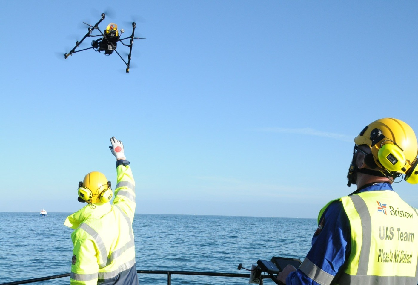 Personnel conducting maritime surveillance with advanced drones to support oil spill response and environmental monitoring operations.