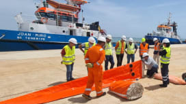 Personnel deploy containment boom during decommissioning preparedness activities for Repsol in Spain.