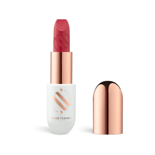 A lipstick packshot with the cap set beside it on white.