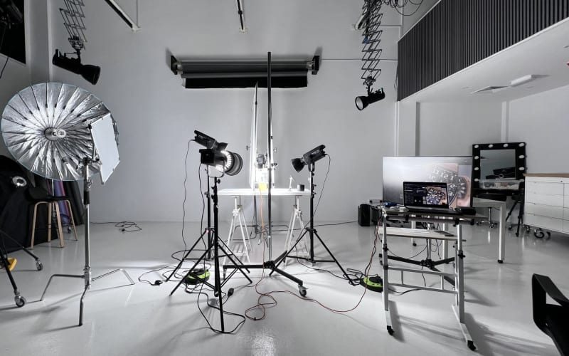 The white studio rigged with lights and modifiers.