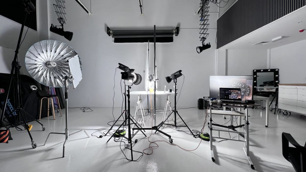 The white studio rigged with lights and modifiers, set and ready between takes.