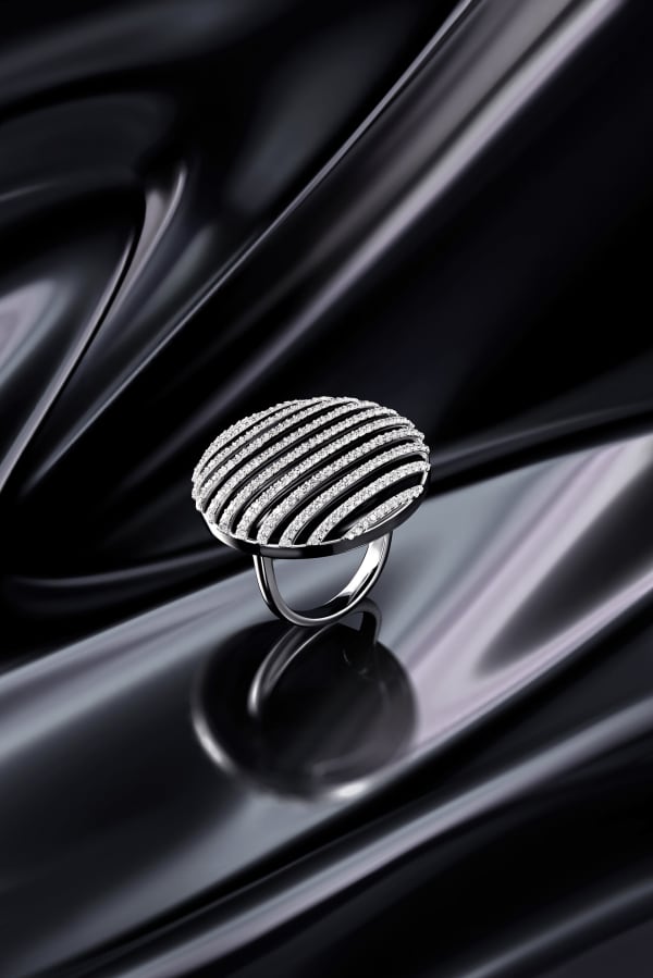 A pavé cocktail ring standing on rippling black silk.