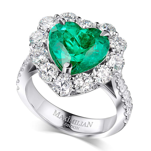 An emerald heart-cut ring surrounded by brilliant diamonds on white.