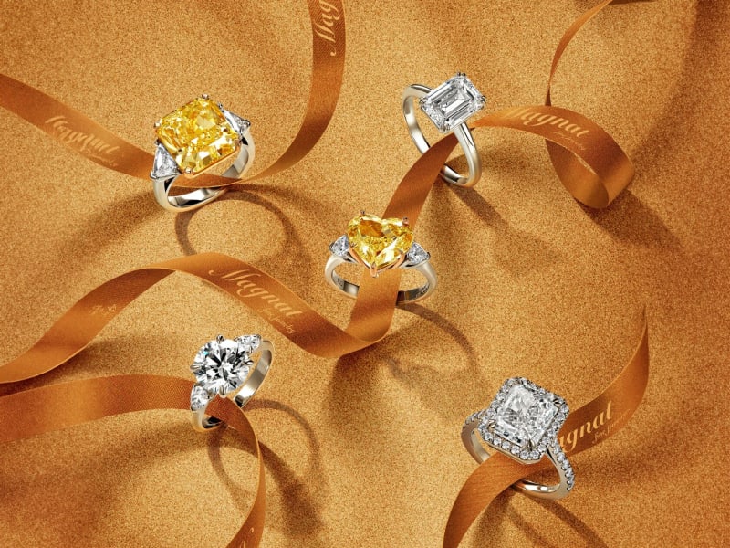 Gold jewelry arranged on a warm textured surface.