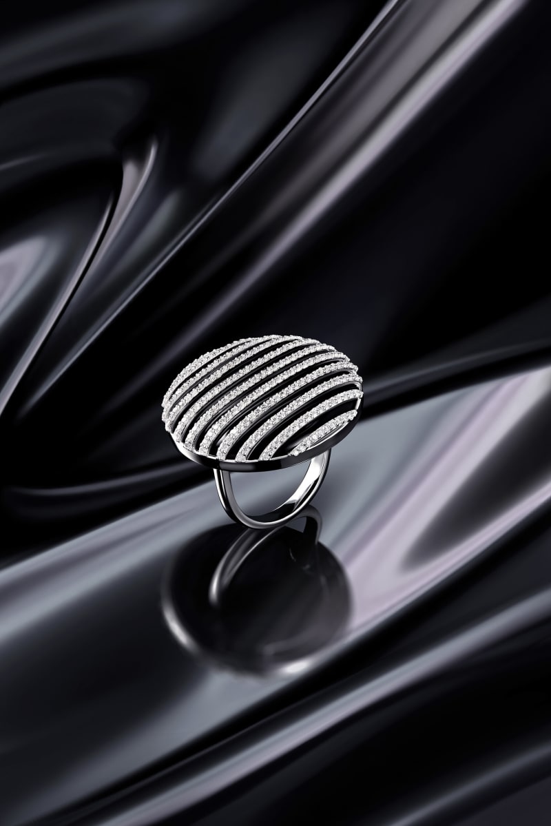 A pavé cocktail ring standing on rippling black silk.