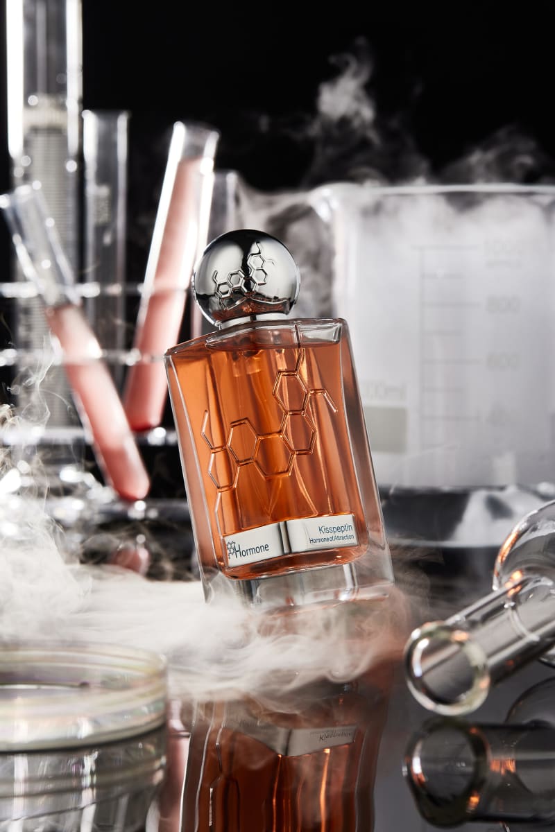 A bottle standing in drifting powder under hard directional light.