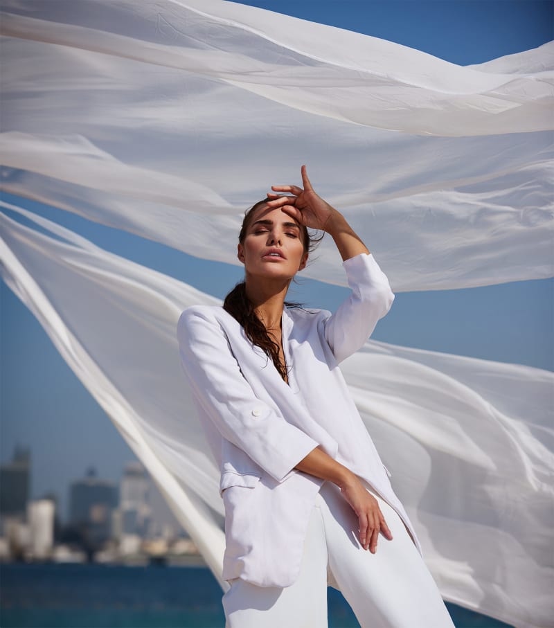 A styled fashion look photographed against a built backdrop.