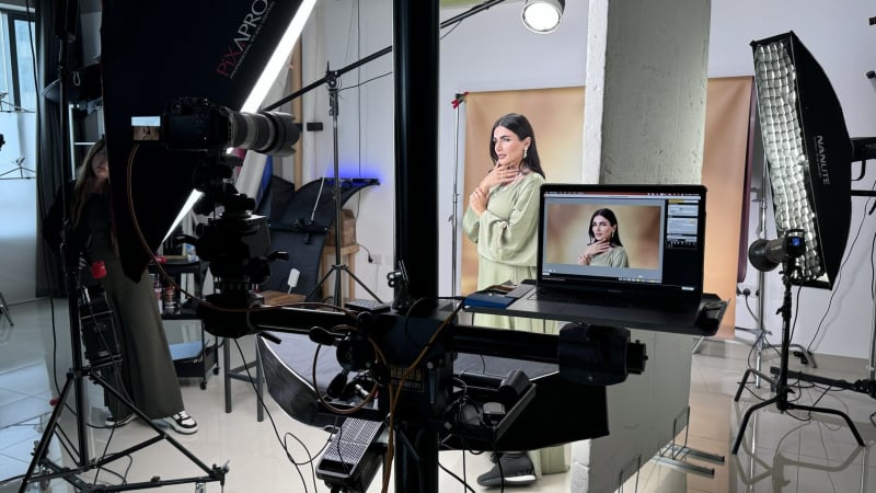 A tethered shoot in progress: the model on set and the captured frame on the laptop screen.