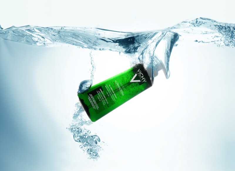 A green cleansing gel plunging underwater with the splash frozen mid-air.