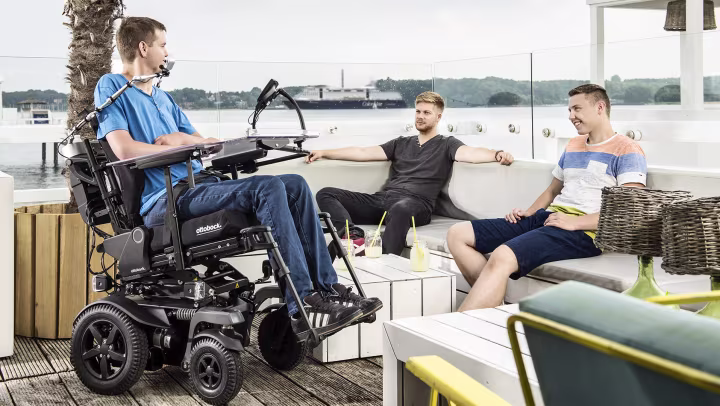 User Pierre in his Juvo power wheelchair from Ottobock chilling in a port cafe.