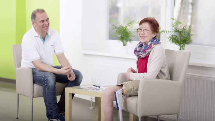 Elisabeth spricht mit dem Orthopädietechniker, wobei sie das Prosedo Sperrkniegelenk trägt.