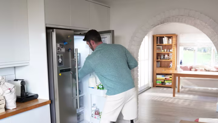 Bilateral Genium X4 user Dave opens the refrigerator and takes a step backwards