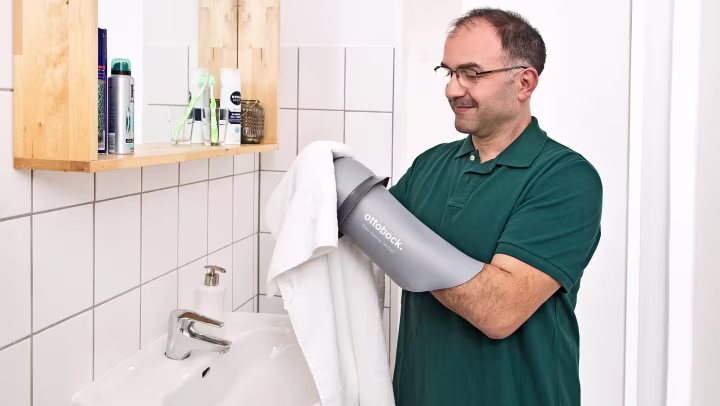 Muž stojí u umyvadla a čistí svůj liner.