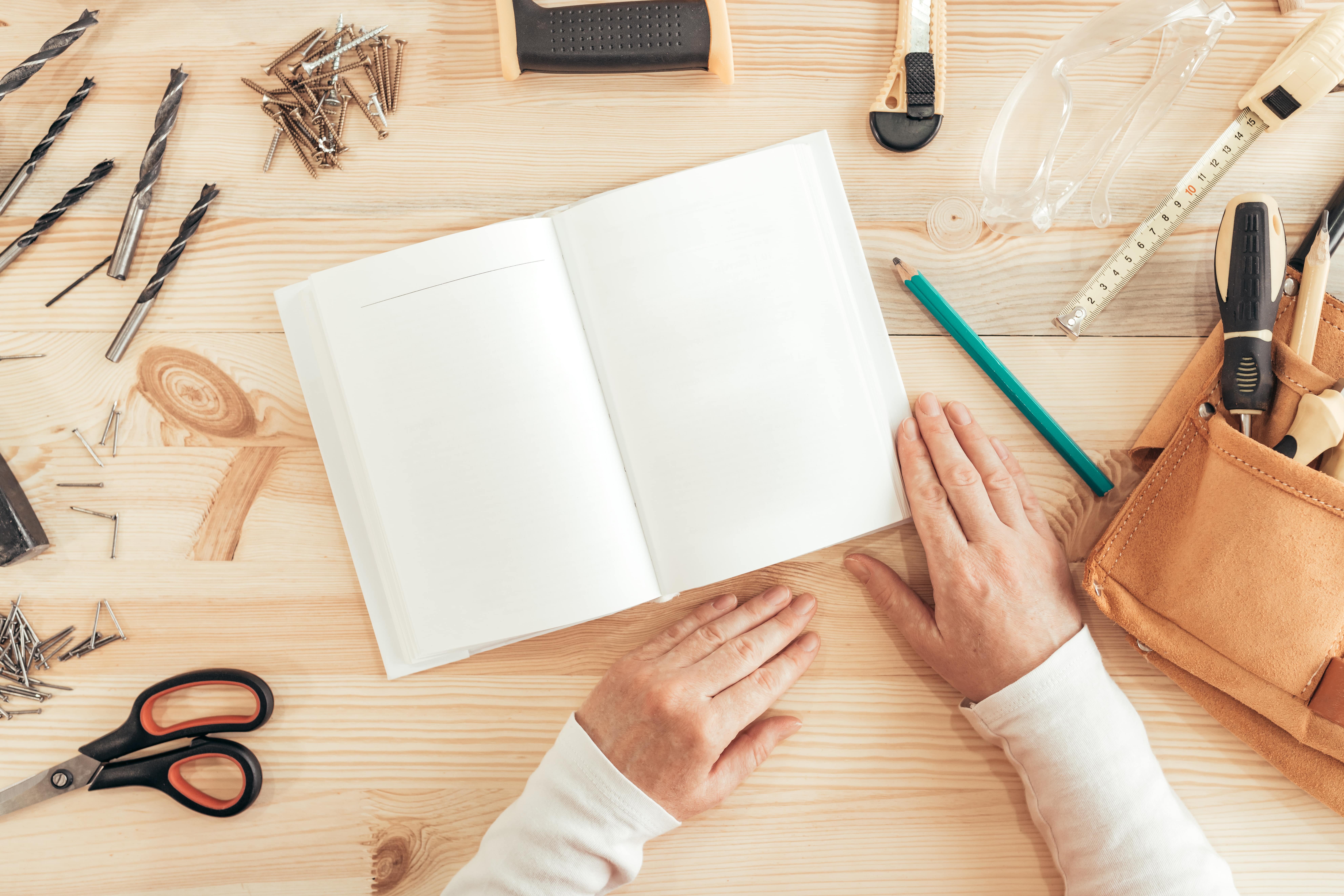 Personne devant une page blanche de cahier sur un plan de travail