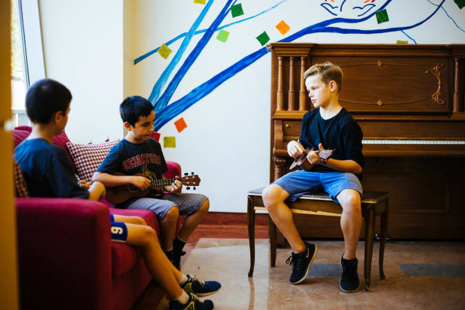 OMS Montessori - Upper Elementary Students playing Ukulele in the common area 