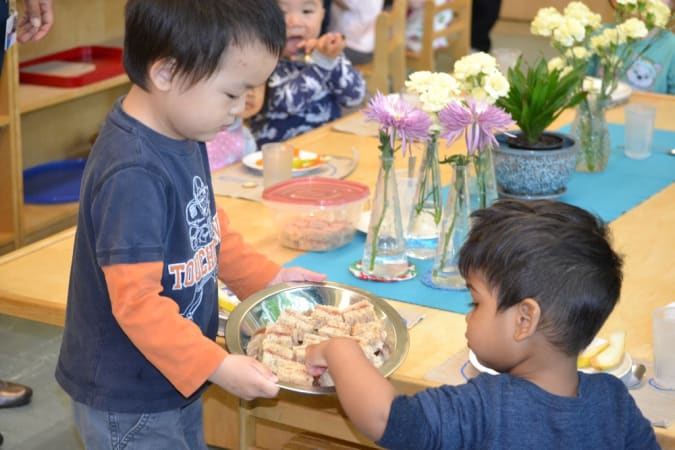 Bishop Hamilton Montessori School - Toddler students practice grace and courtesy during snack time. 