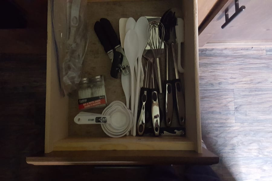Set of 4 silverware,  measuring cups, tsp/tbsp measure, can opener, spatula, serving spoons. Whisk, slotted Turner, slotted spoon.