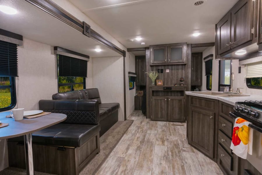 Cozy rv rental interior: dining nook, sofa, and kitchen make for a comfortable travel space.