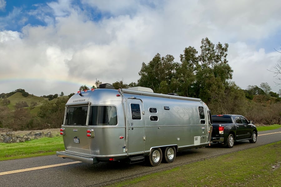 This Airstream RV rental is ready for a scenic road trip under a rainbow. Experience camping adventure!