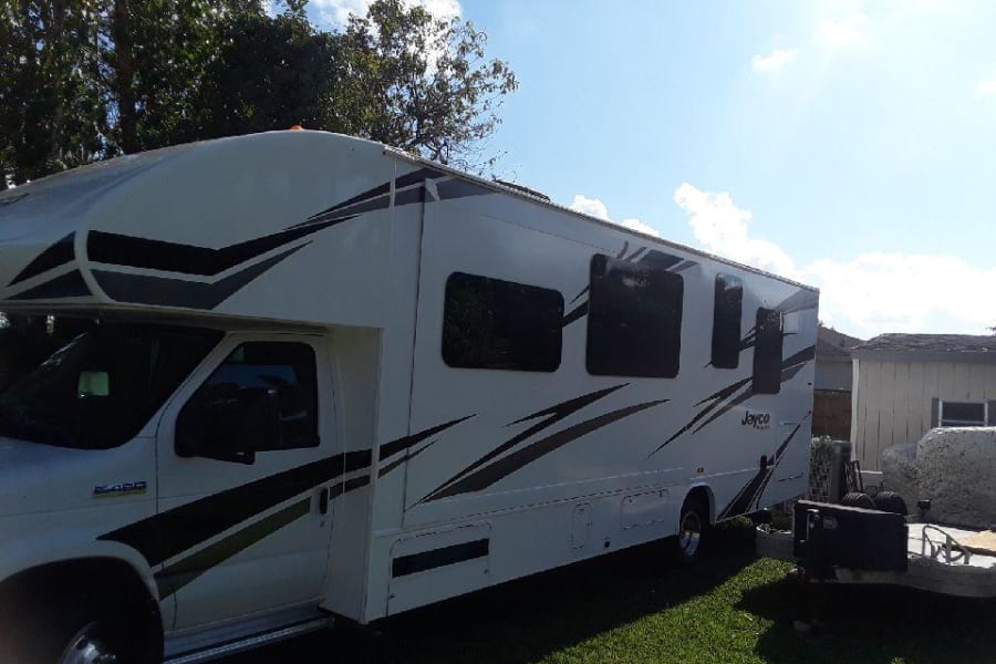 This white Jayco Class C RV rental, a Ford E-450, is parked outside, ready for your next adventure.