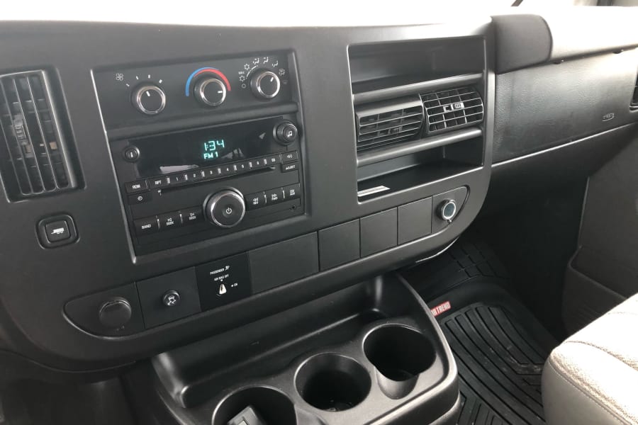 RV rental van dashboard with climate, audio controls, and cupholders ready for your adventure.