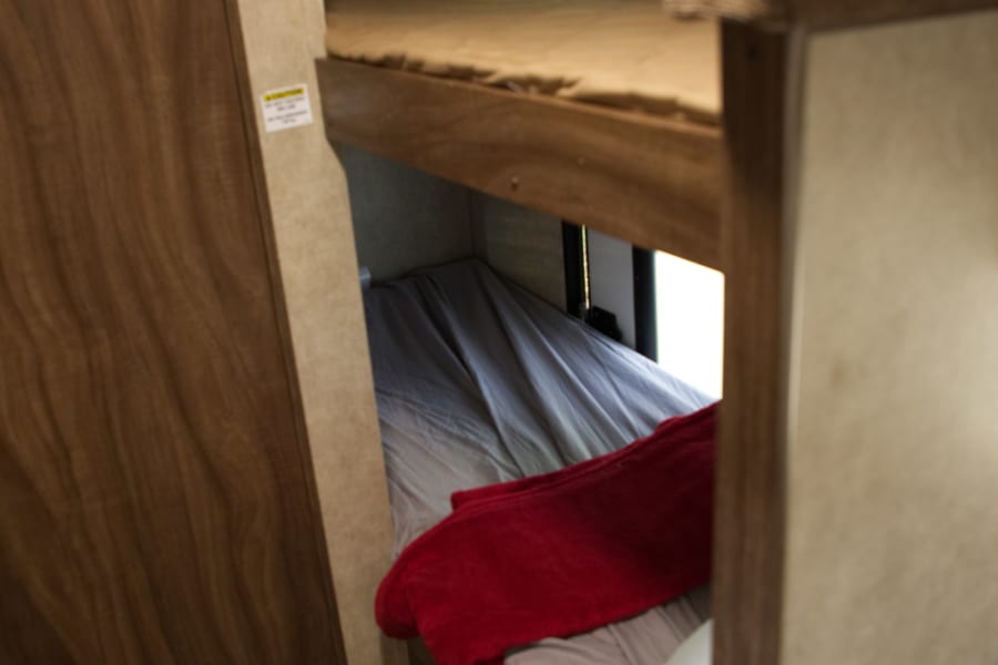 View of comfortable bunk beds in an RV rental, offering cozy sleeping space for your next travel adventure.