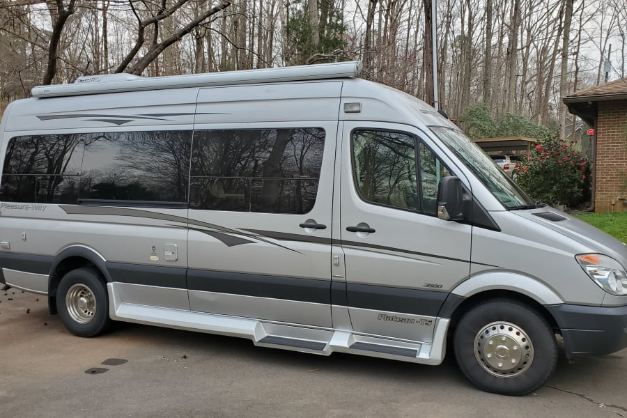 Explore with this rv rental, a silver Pleasure-Way Plateau-TS camper van, parked outdoors ready for adventure.